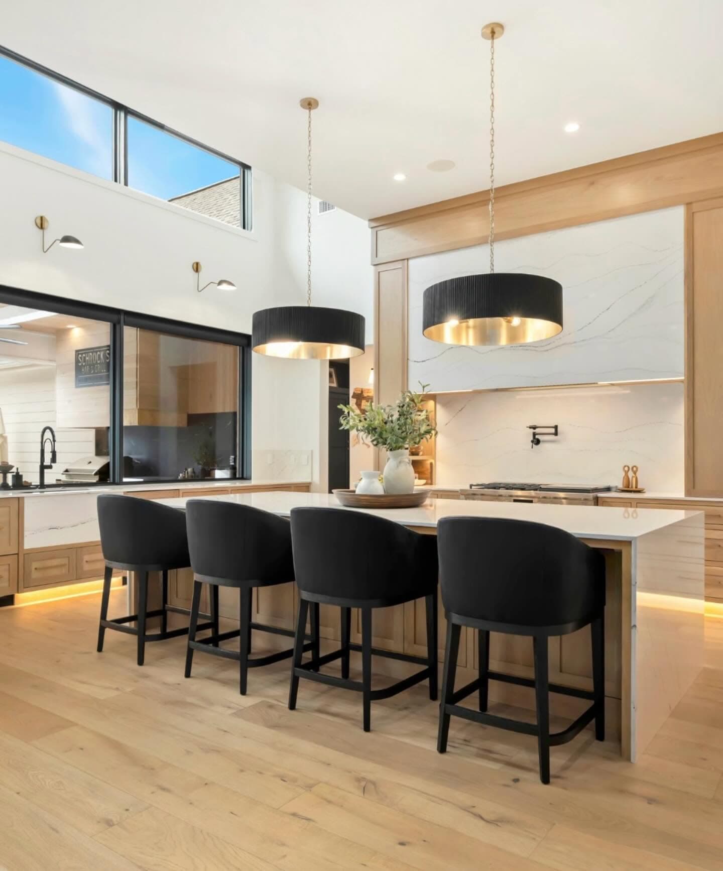 Modern kitchen with marble waterfall island and wood cabinetry